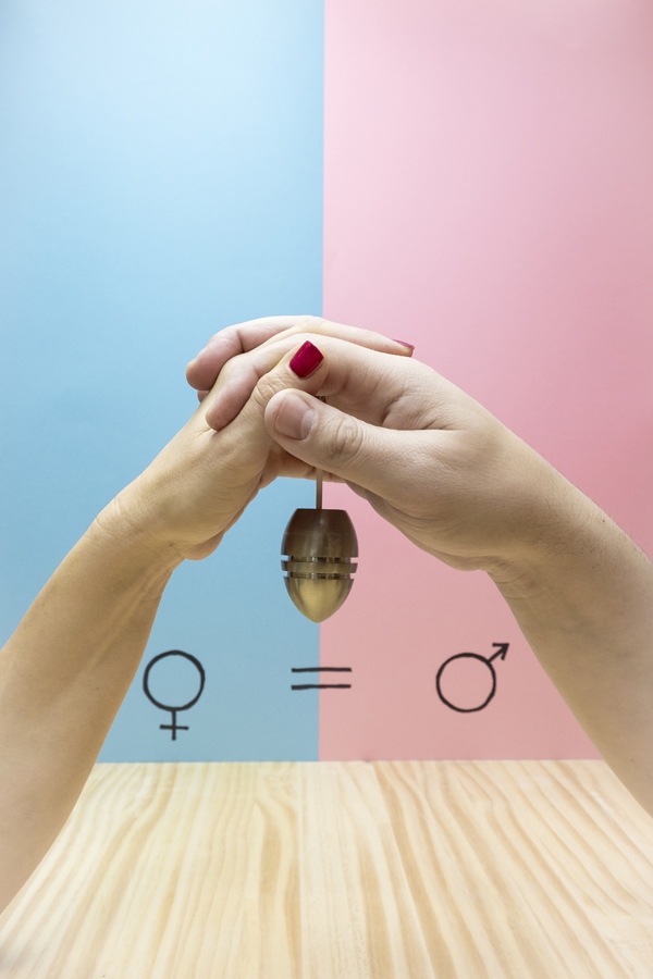 Les mains d'un homme et d'une femme tenant un poids à côté du symbole de l'égalité des sexes